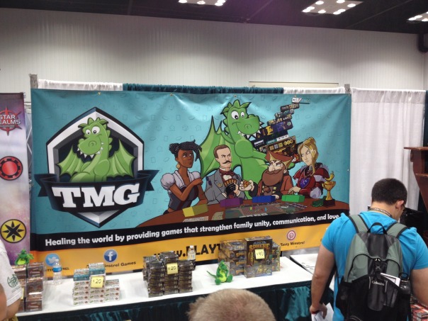 TMG Booth Banner. Check out the awesome game they've got on their table!